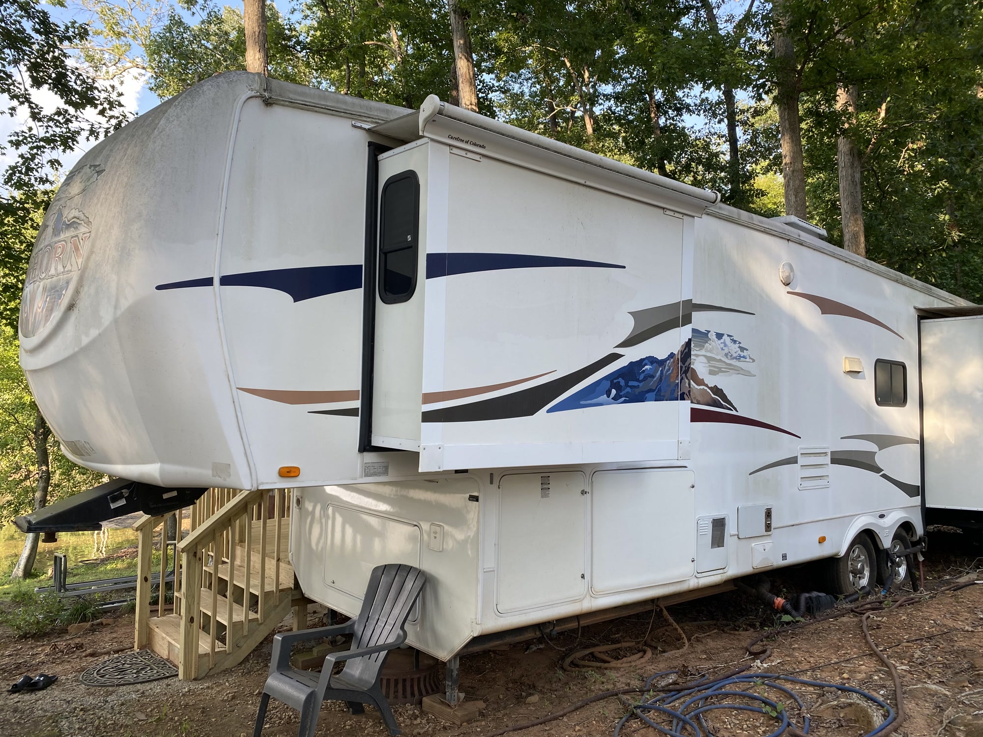Full side view of the furnished fifth wheel camper rental and its deck at Bear Creek Marina on Jackson Lake